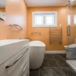 Salle de bain rénovée dans les tons chauds avec baignoire